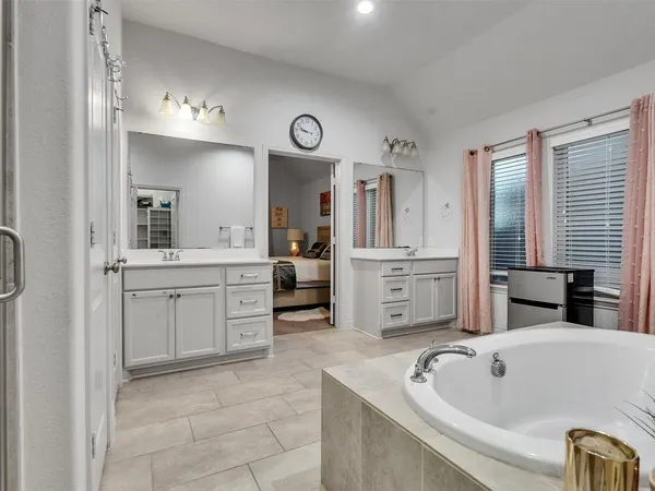 a bathroom with a tub sink and mirror