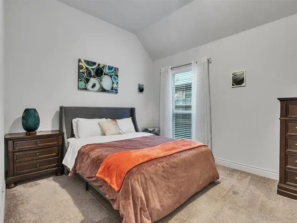 a bedroom with a bed a lamp and window