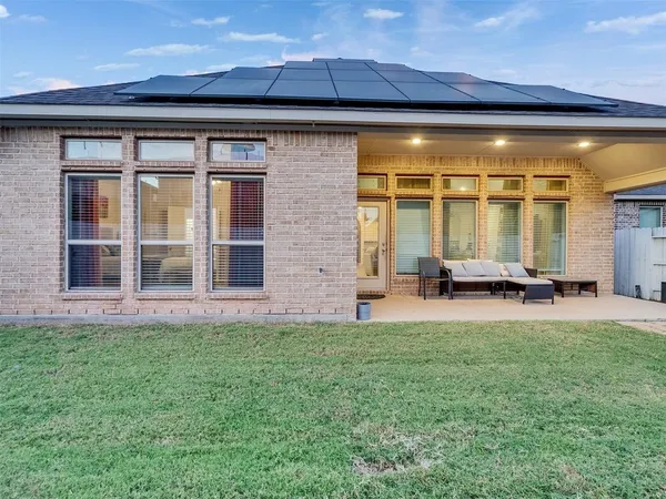 a view of a house with a patio and a yard