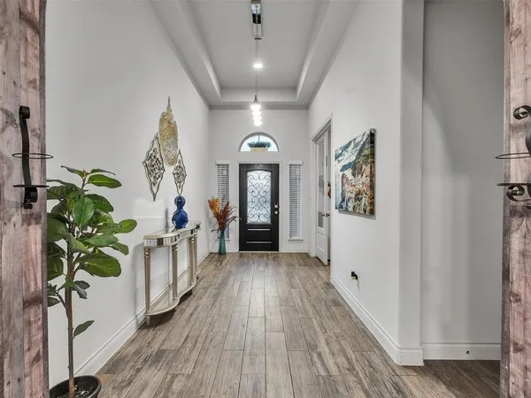 a view of a hallway with wooden floor and a potted plant