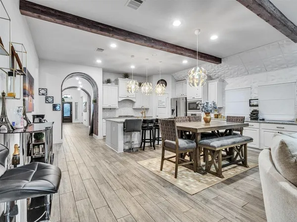 a living room with stainless steel appliances kitchen island granite countertop furniture a rug and a kitchen view