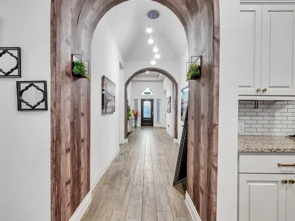 a view of a hallway with wooden floor and staircase