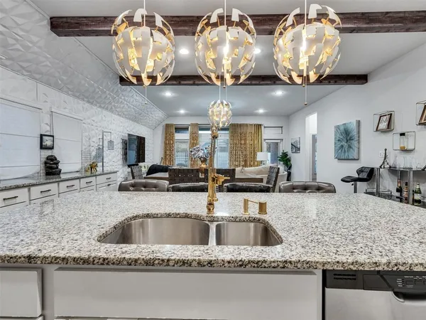 a kitchen with stainless steel appliances granite countertop a sink a stove and a granite counter tops