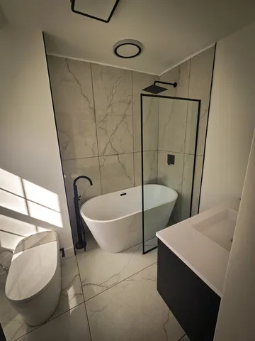 a bathroom with a tub sink and mirror