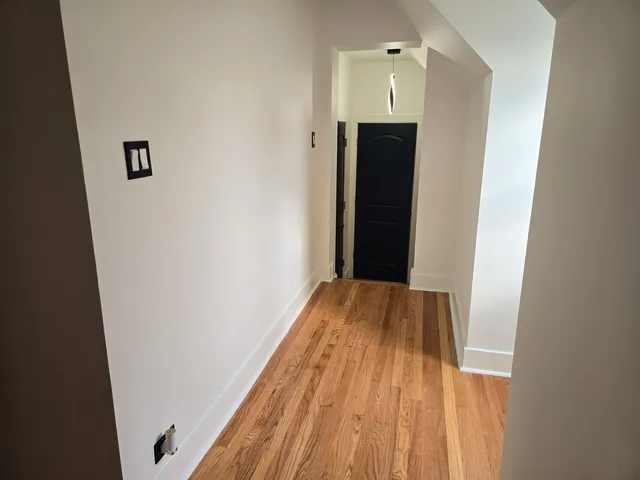 a view of an empty room with wooden floor