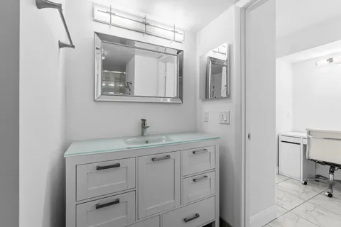 a bathroom with a toilet sink vanity and mirror