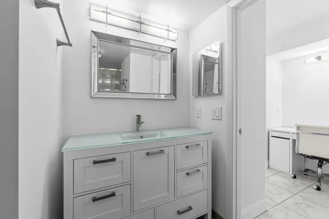 a bathroom with a toilet sink vanity and mirror