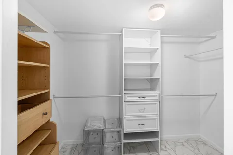 a view of walk in closet with empty racks