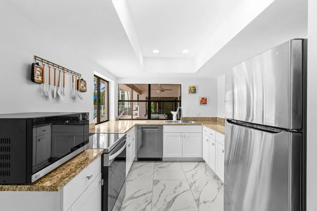 a kitchen with a refrigerator and white cabinets