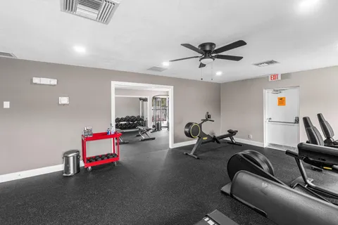 a living room with furniture and a gym machine