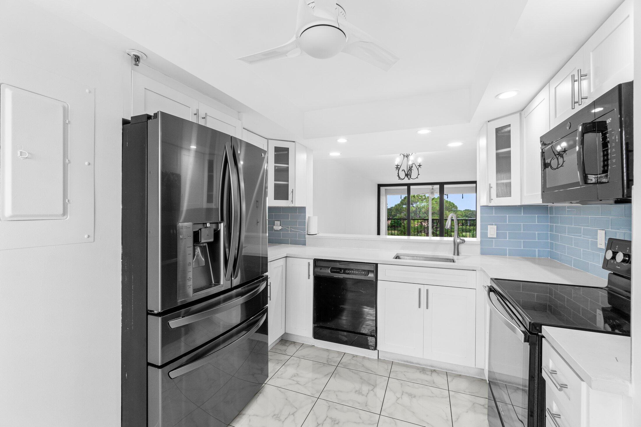6562 Boca Del Mar Drive, Unit 527 Boca Raton, FL 33433 - Photo 4 of 38 a kitchen with a sink stainless steel appliances and cabinets
