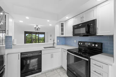 a kitchen with cabinets stainless steel appliances and a sink