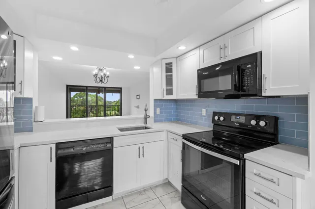 a kitchen with cabinets stainless steel appliances and a sink