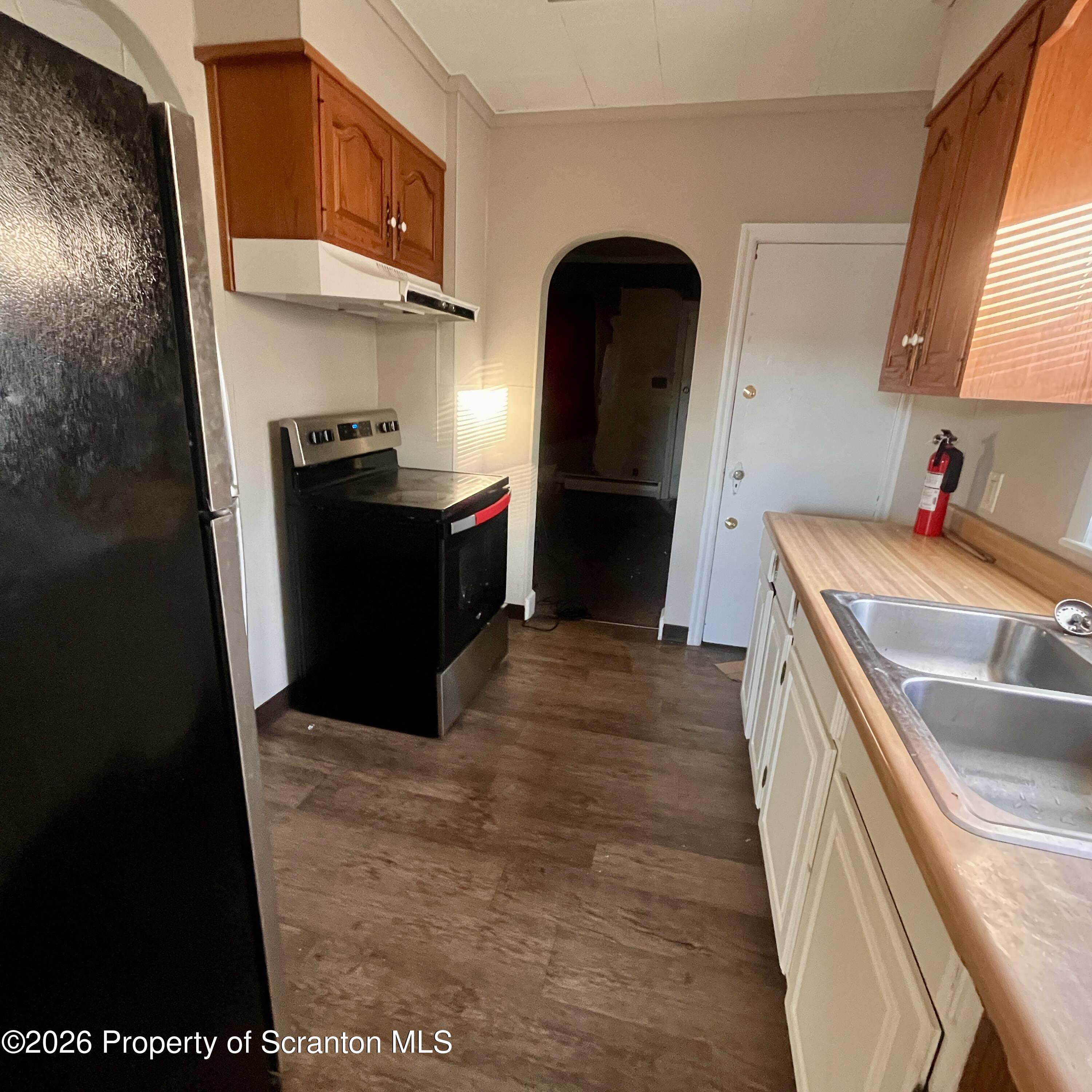 707 Prospect Avenue, Unit REAR Scranton, PA 18505 - Photo 6 of 11 a kitchen with stainless steel appliances granite countertop a refrigerator a stove and a sink
