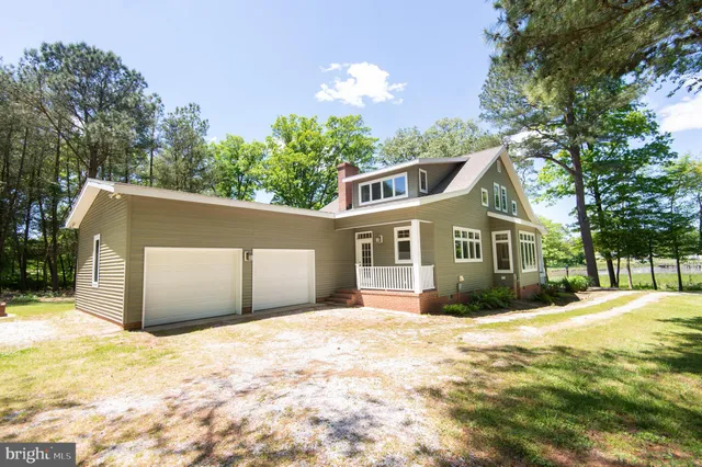 a front view of a house with a yard covered in snow