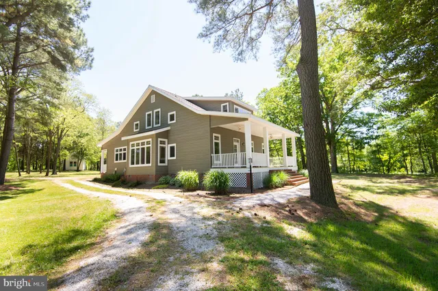 a front view of a house with a yard and trees