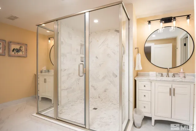 a bathroom with a granite countertop sink mirror and a shower