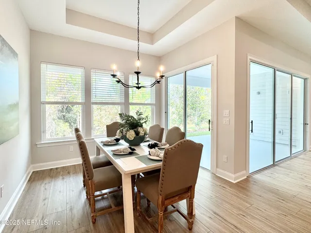 a view of a dining room with furniture wooden floor and chandelier