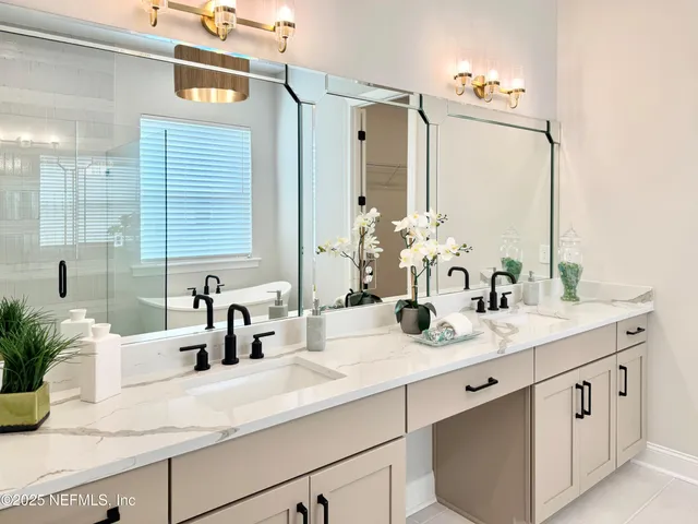 a bathroom with double vanity sinks a vanity and a mirror