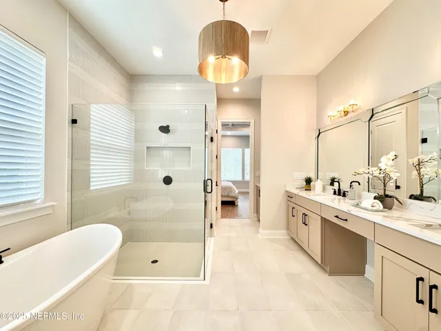 a spacious bathroom with a tub sink and mirror