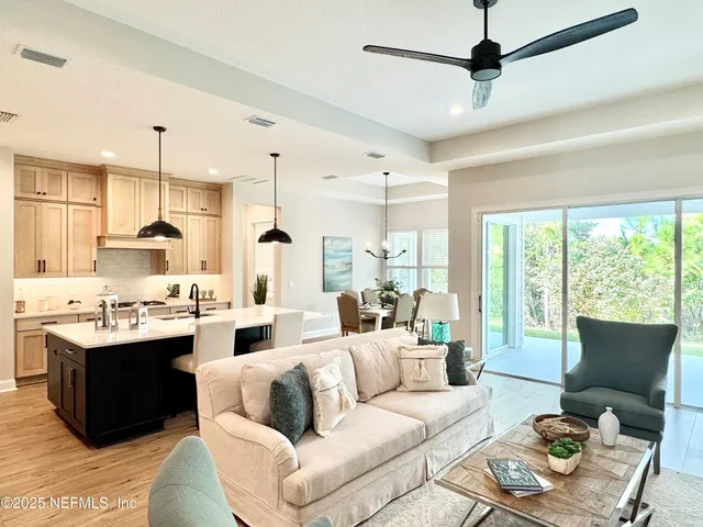 a living room with stainless steel appliances kitchen island furniture and a large window