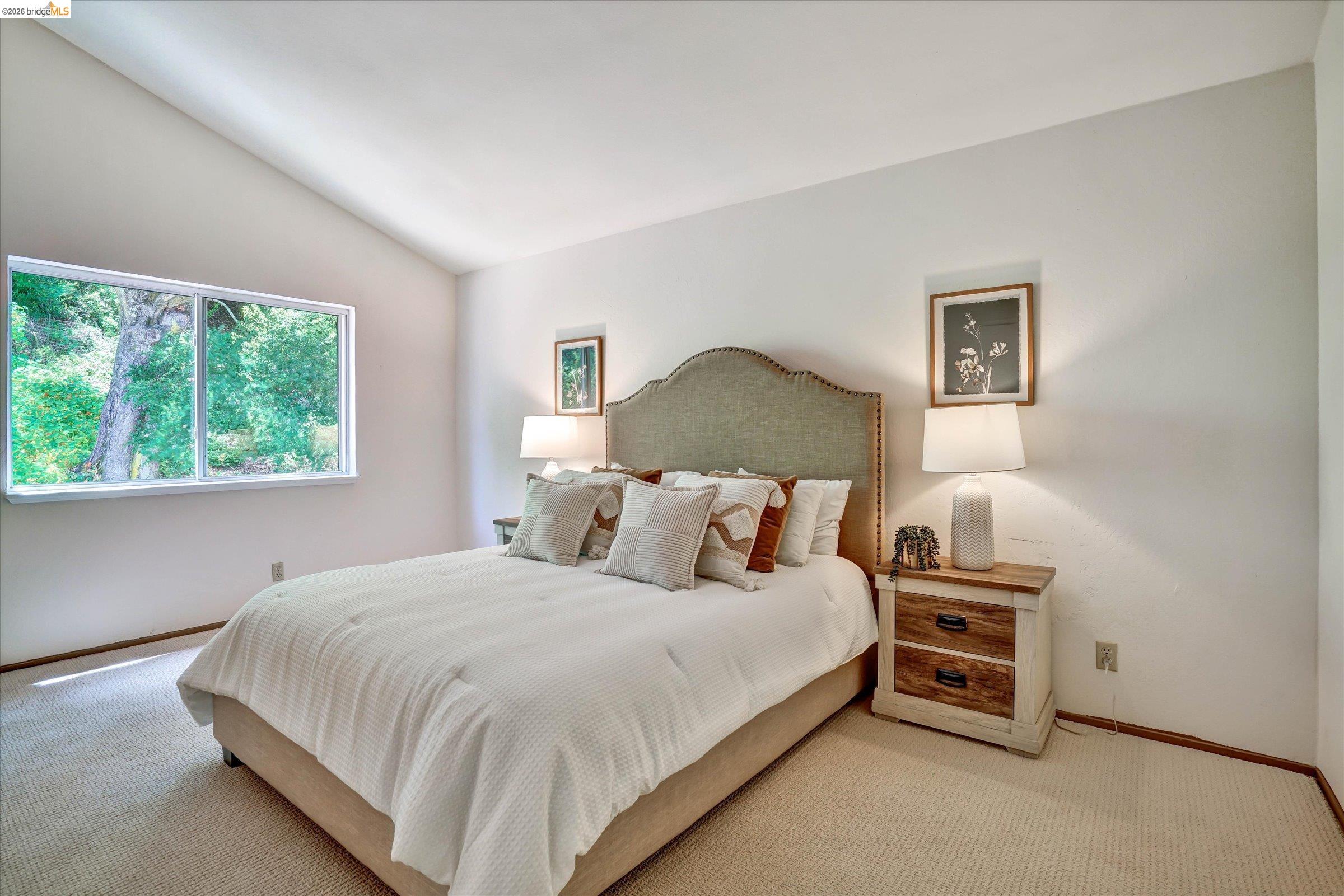 2826 Wright Avenue Pinole, CA 94564 - Photo 41 of 70 Vaulted ceiling bedroom featuring a large picture window with a green landscape backdrop, light-toned carpet, and baseboard trim