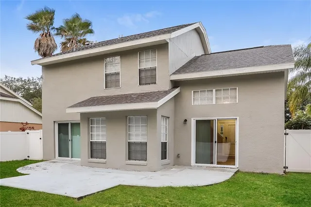 a view of a house with potted plants and a yard