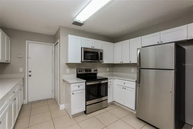 a kitchen with white cabinets and stainless steel appliances