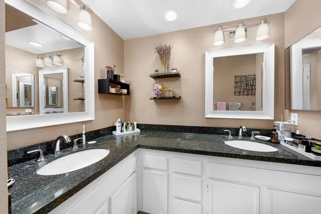 a bathroom with double sink and a mirror