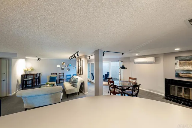 a living room with furniture and a dining table with kitchen view