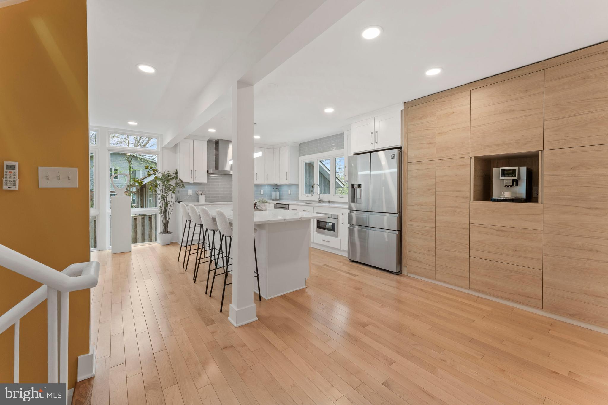 6522 Walhonding Road Bethesda, MD 20816 - Photo 13 of 76 a kitchen with stainless steel appliances kitchen island granite countertop a stove top oven a sink a refrigerator white cabinets and wooden floor