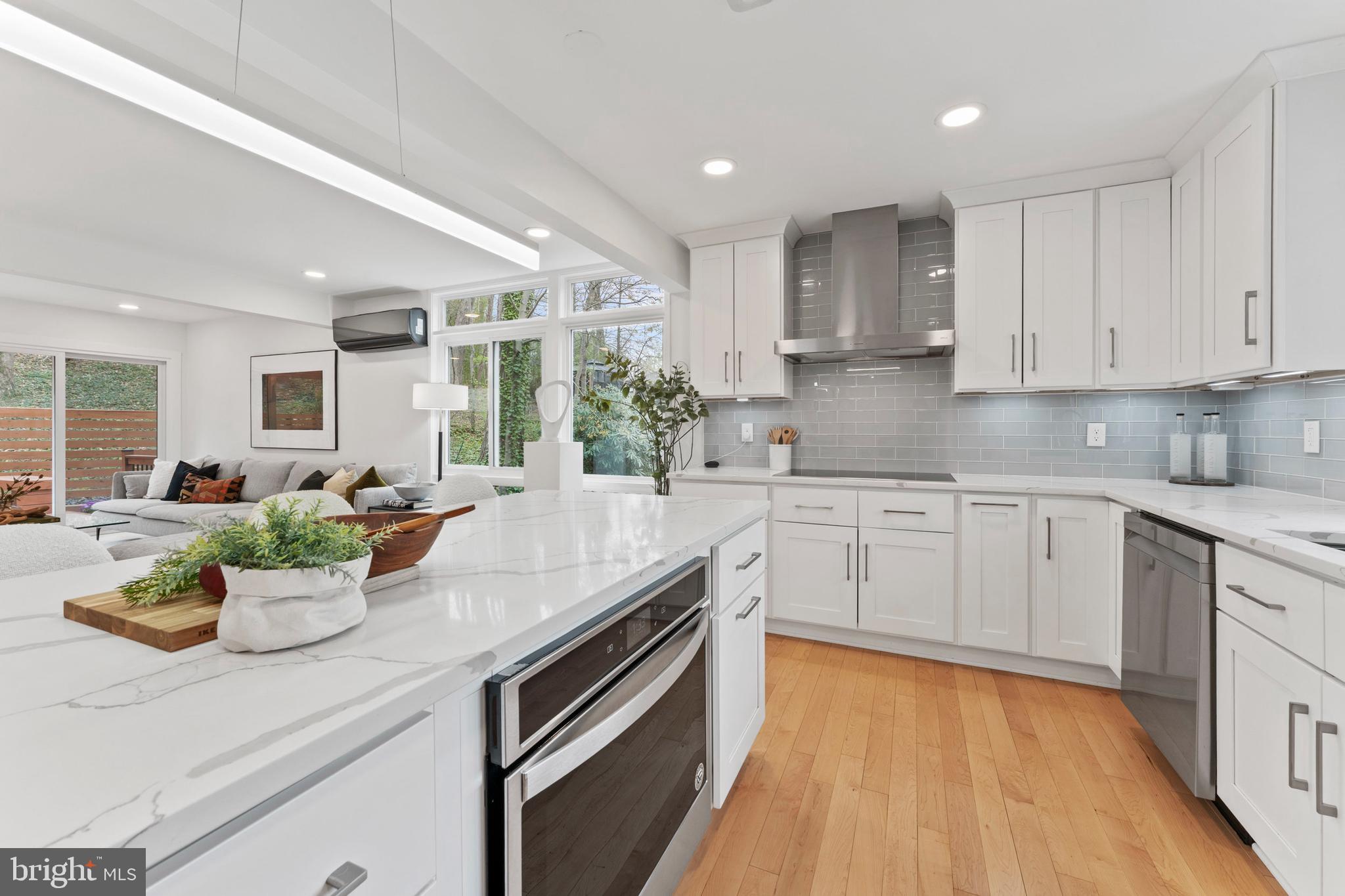 6522 Walhonding Road Bethesda, MD 20816 - Photo 8 of 76 a kitchen with a sink a stove cabinets and living room view