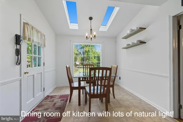 a dining room with furniture a chandelier and window