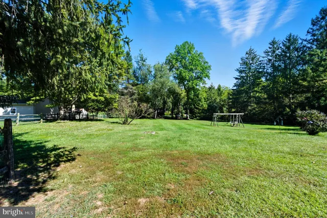 an aerial view of residential houses with outdoor space and trees