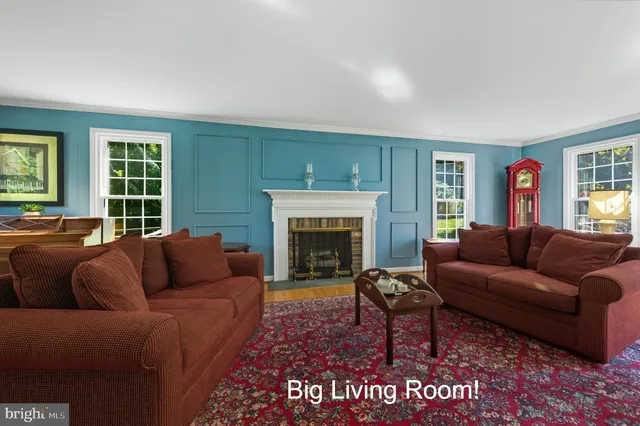 a spacious bedroom with a bed a couch and a dresser next to a window