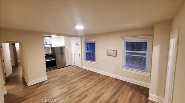 a view of a kitchen with wooden floor and electronic appliances