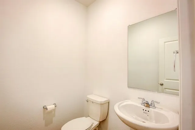a bathroom with a sink a toilet and mirror