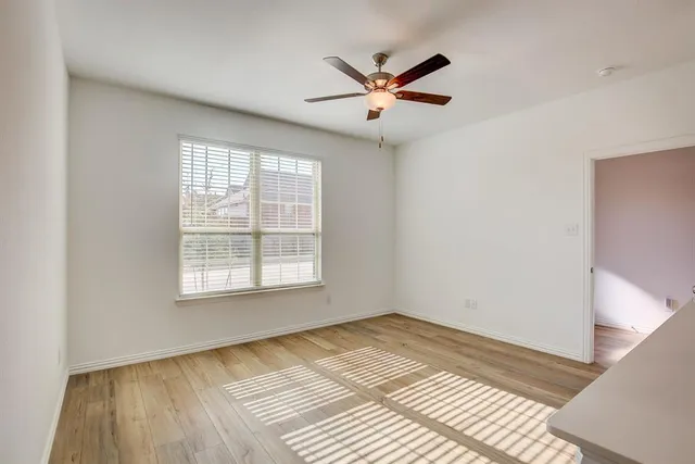 a view of a big room with wooden floor and windows