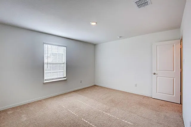 a view of a hallway with wooden floor and a small yard