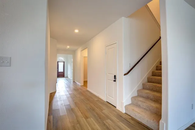 a view of a hallway with wooden floor and entryway