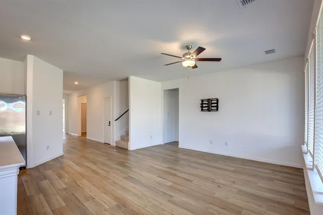 a view of a room with wooden floor and a ceiling fan