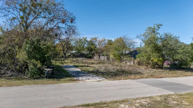 a view of backyard with wooden fence and trees