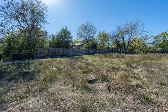 a backyard of a house with large trees and outdoor seating