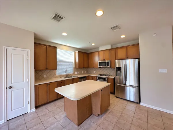a kitchen with stainless steel appliances granite countertop a refrigerator and a sink