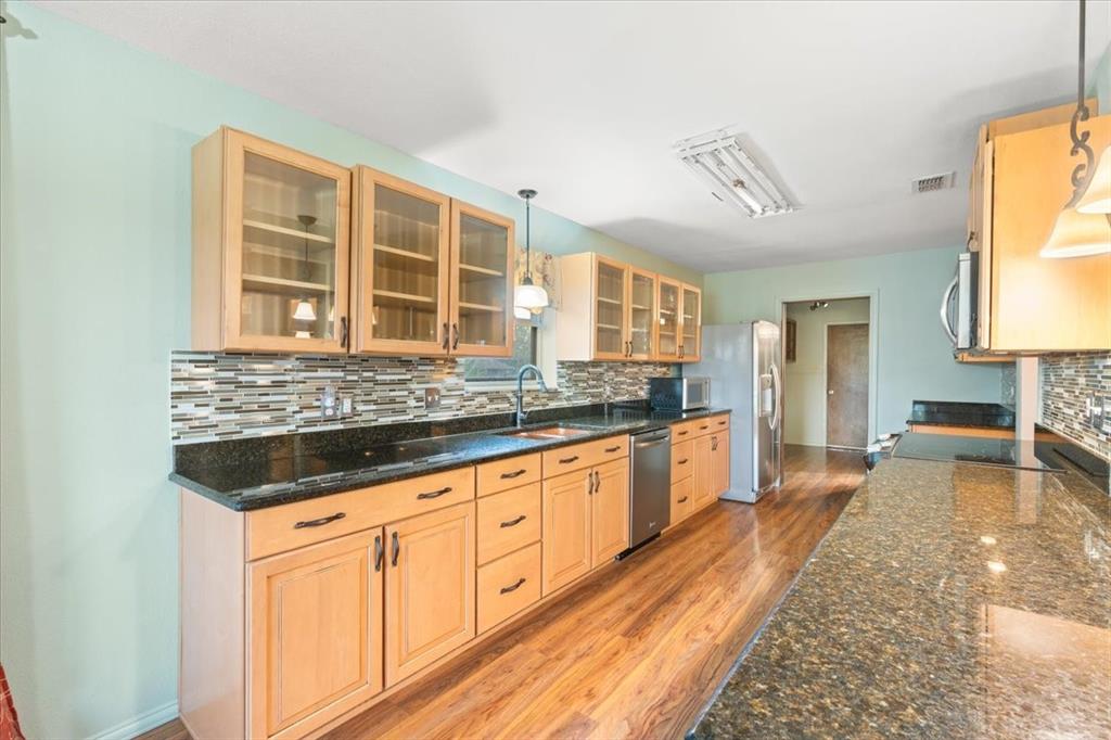 105 Riverside Drive Mineral Wells, TX 76067 - Photo 40 of 40 Kitchen with light brown cabinets, backsplash, pendant lighting, stainless steel appliances, and open floor plan