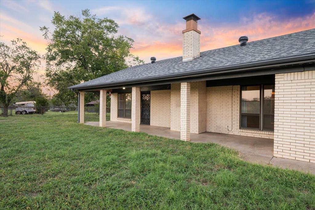 105 Riverside Drive Mineral Wells, TX 76067 - Photo 30 of 40 Rear view of house with a patio, brick siding, a chimney, and a shingled roof