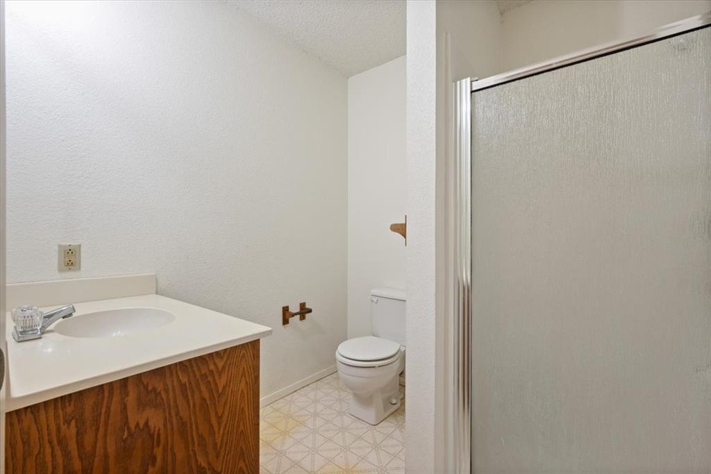 105 Riverside Drive Mineral Wells, TX 76067 - Photo 34 of 40 Full bathroom featuring vanity, a stall shower, and a textured ceiling