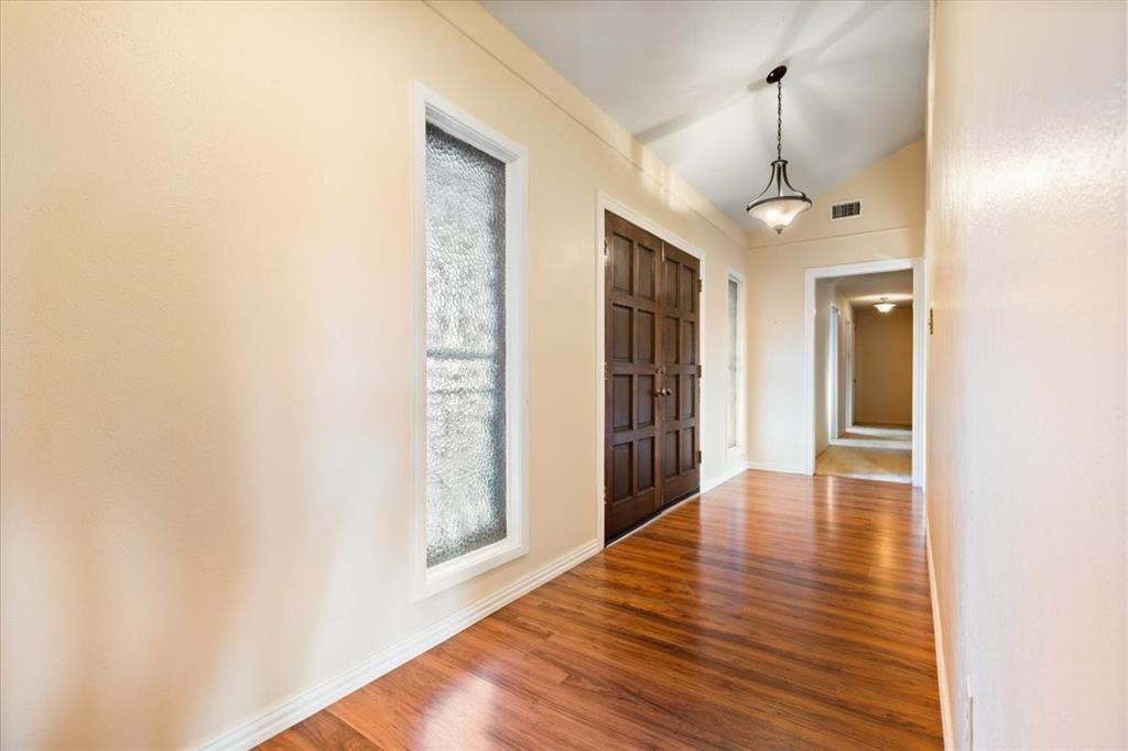 105 Riverside Drive Mineral Wells, TX 76067 - Photo 5 of 40 Unfurnished living room with a brick fireplace, a ceiling fan, lofted ceiling, and wood finished floors