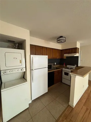 a kitchen with a refrigerator and a stove top oven