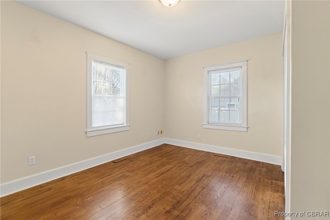 5633 Wilson Creek Road Virginia Beach, VA 23464 - Photo 18 of 44 Empty room with baseboards, a healthy amount of sunlight, and dark wood-type flooring